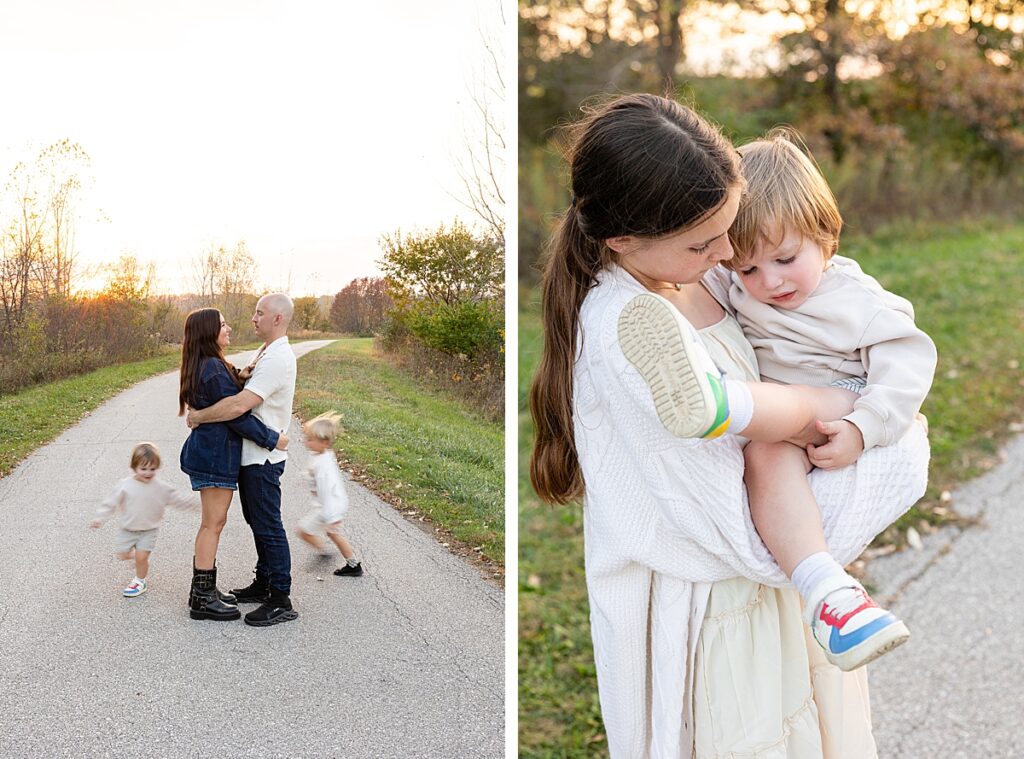 Parents standing together on a path as children run in motion around them; young girl holding her toddler sibling.
