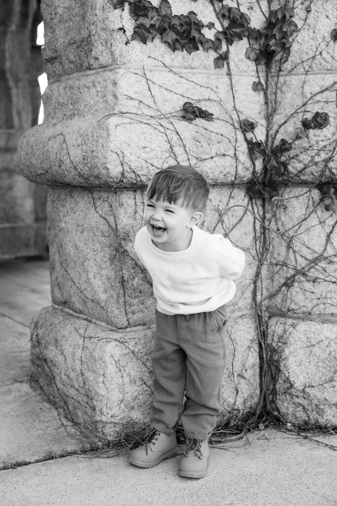 Black and white portrait of a laughing boy at Lincoln Park Nature Boardwalk in Chicago.
