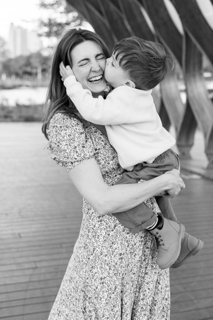 Toddler kissing his mother’s cheek during a family session at Lincoln Park Nature Boardwalk in Chicago