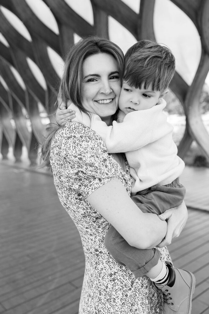 Mother holding her toddler son during a family photo session with a Chicago family photographer at Lincoln Park Nature Boardwalk.